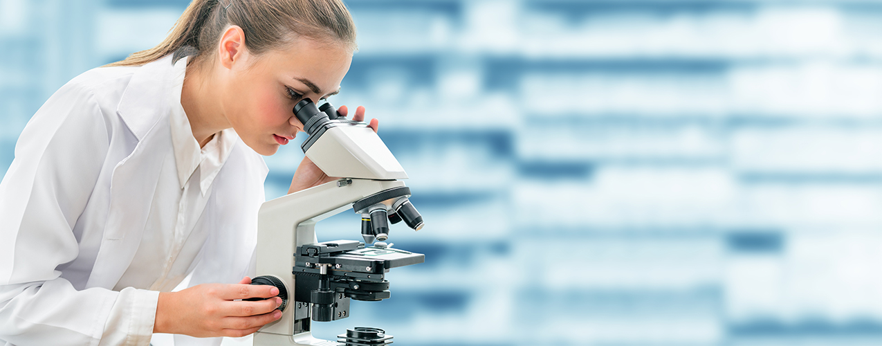 Researcher looking through microscope